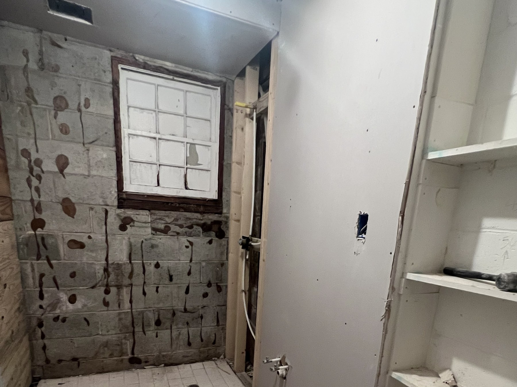 Gutted bathroom with exposed block and unfinished drywall