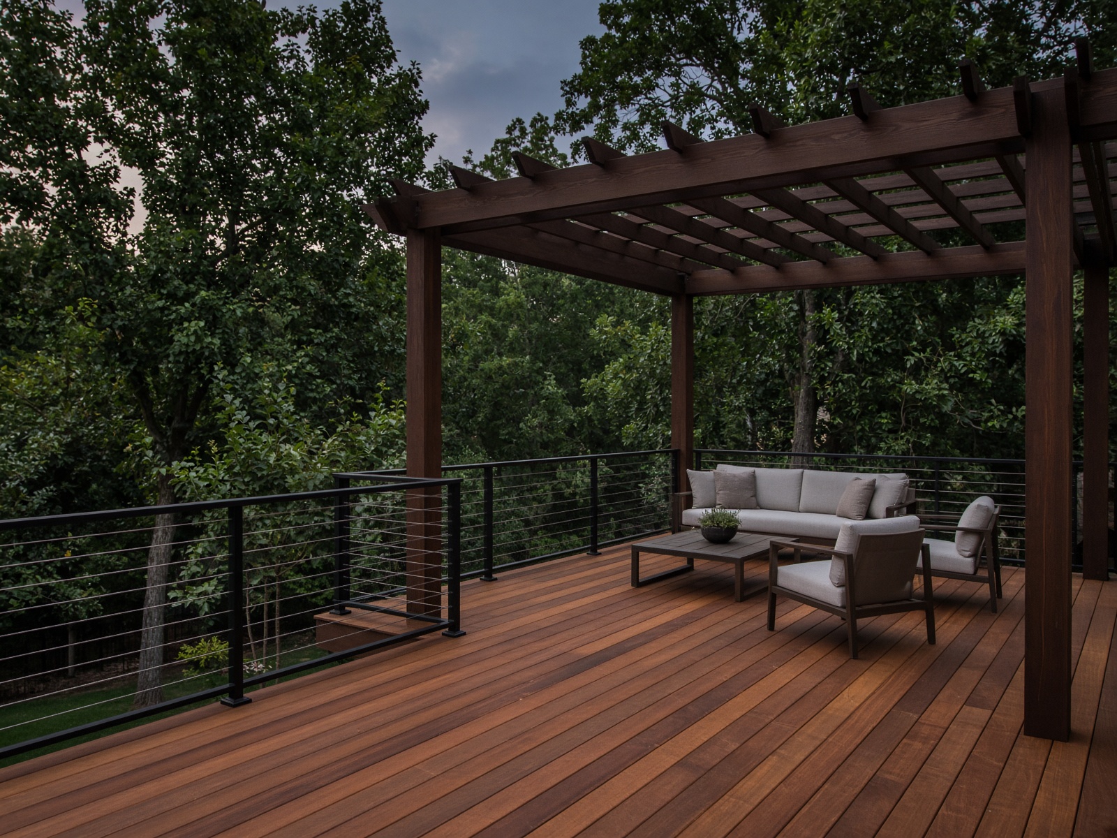 New ipe deck with black cable railing at dusk